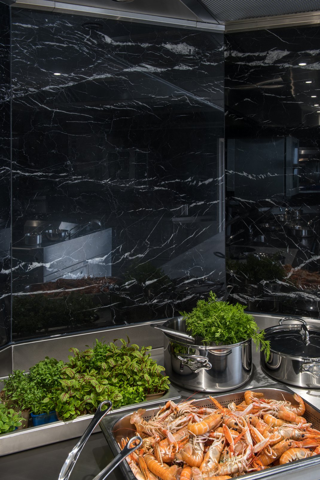 Cuisine inox avec habillage des murs en marbre noir et sol en terrazzo - Le Donjon Domaine Saint Clair - Etretat - France