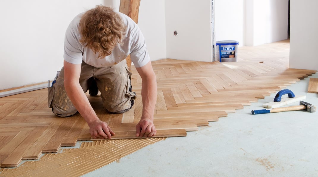 Bodenleger bei der Parkettverlegung in einem Wohnraum in München
