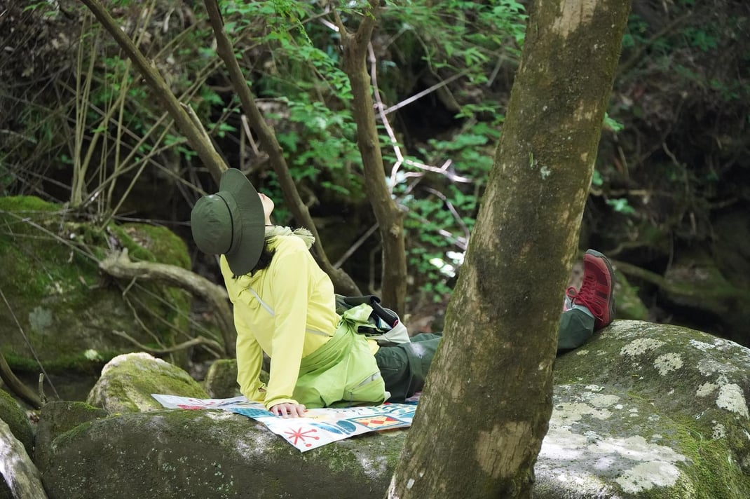 大きな岩の上で自然を感じるソロタイム