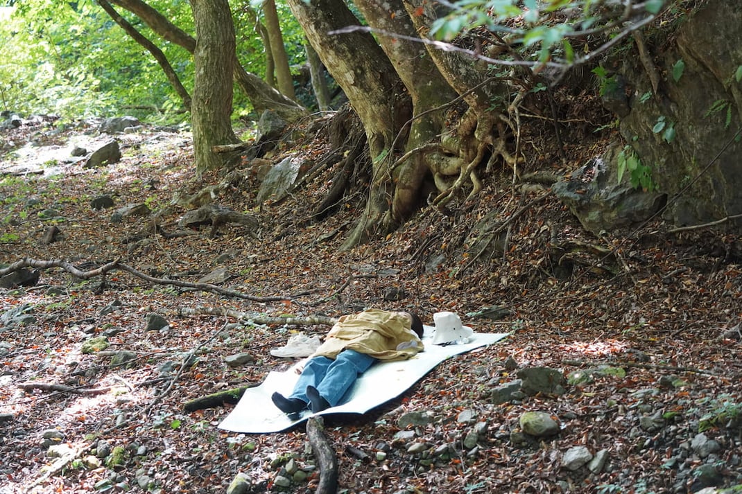 樹の下で静かに横になる参加者