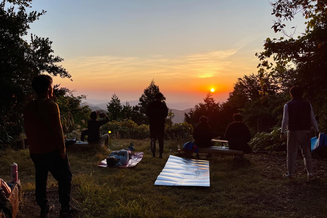 仲間と迎える夜明け（竹寺・鐘楼堂より）