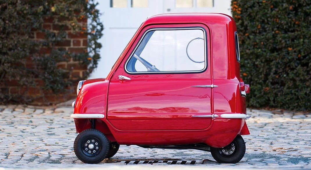 Червоний автомобіль Peel-P50 на бруківці 