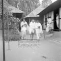 Mahatma Gandhi and others walking on an ashram compound during his peace march in Noakhali, c. November 1946.