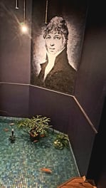 Portrait of 18th century Riga architect Christof Haberland with fish pond in foreground in Riga's Boutique Hotel Kristof