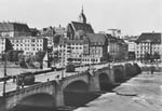 Die Mittlere Brücke mit zwei Trammotorwagen der Linie 6. Blick Richtung Grossbasel: Blaues Haus, Martinskirche, Café Spillmann, Buchhandlung Wepf, Globus, Restaurant Lällekönig, Schifflände, ca. 1947.