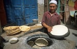 Backen von Fladebrot im Tandori-Ofen, Kashgar, Provinz Xinjiang, VR China
