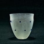 Konischer Becher mit leichter Einschnürung unterhalb des Mundrandes. Leicht grünliches, milchig-weißes Glas mit kleinen blauen Nuppen. datiert: um 300 n.Chr., Fundort:Köln (1906), Inv. Nr 981 Höhe ca 92 mm, Gefäß Nr. 109/157