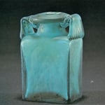 Flache blaugrüne Vierkantflasche mit umgelegtem Kragen und zwei breiten, starkt gerippten Henkeln, in Halbform geblasen.  2. Jh.n.Chr.  Höhe ca 145 mm  Inv. Nr. N 354  Fundort Köln, Neusser Straße  Gefäß Nr. 108/156