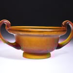 Kantharos mit 2 ausladenden Griffen auf Fuß gearbeitet. Braungelbes Glas.  1. Jh.n.Chr.  Musée des Antiquites nationales, St.-Germain-en-Laye  Inv. AN 24636  Fundort: Saintes (Charente Maritime) Höhe ca 54 mm, Durchm. 110 mm  Gefäß Nr. 423