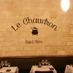 Reproduction du sigle en lettres peintes sur mur de pierre