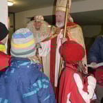 Gemeinsam mit dem Weihnachtsengel verteilt der Nikolaus Geschenke an die Kinder