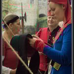 Mise en place de la bande de velours noir sur la coiffe d'une cliente. On peut voir le petite "bandeau" de velours noir sur la tâte, qui maintiendra la coiffe en place.