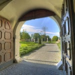 Blick durch das Tor der Pforte in Richtung der Gartenanlage