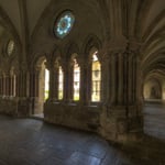 Blick in den Kreuzgang und den Garten mit der Kirche