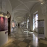 Das Bild unten zeigt den Gang zum Fest- oder Altmannisaal mit einem historischen Überblick über die Stiftsgeschichte.