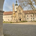 Blick auf die romanische Westfassade der Stiftskirche (1187), im Vordergrund die Dreifaltigkeitssäule (1729-1739)
