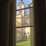 Blick aus dem Kreuzgang über den Garten auf die Kirche