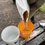 Das Saatgut wird in Eimern portioniert.