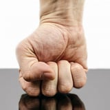 poing qui frappe la table