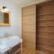 脱衣室は広く、タイルの洗面台に収納スペースを設けています。