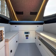 Innenausbau Flatbed Camper mit großem Bett, Sitzmöglichkeiten und vielen Verstaumöglichkeiten für flexibles Camping