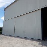 Porte coulissante grise de hangar par ACMB Charpente metallique construction Brioux 79