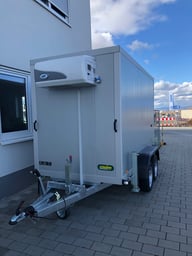 alt="Zweiachsiger Kühlanhänger, perfekt geeignet für den Transport temperaturempfindlicher Waren."