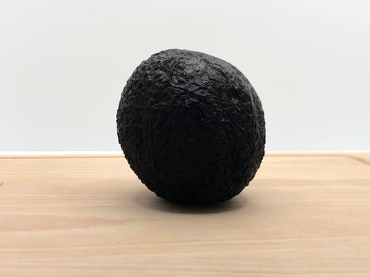 Avocat bio sur une planche en bois et fond blanc