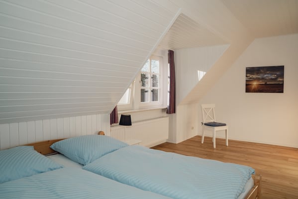 Blick in eines der beiden Schlafzimmer mit Doppelbett.