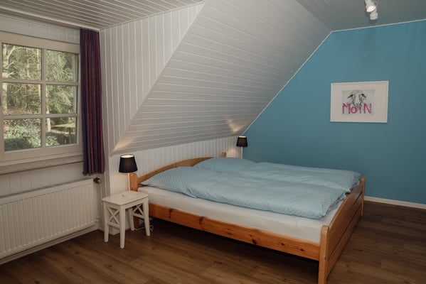 Blick in das zweite Schlafzimmer, das ebenfalls mit einem Doppelbett ausgestattet ist.