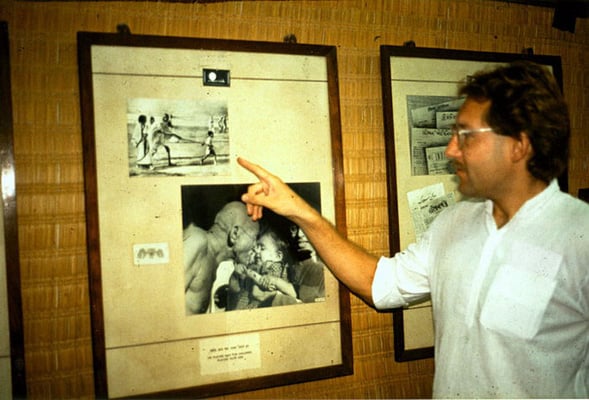 Peter Rühe pointing out the photograph that often is wrongly captioned as “The Leader being led”. Peter got it confirmed from the small boy in the picture, Gandhi’s grandson Kahandas (“Kanaa”, “Kanu”) , that it were two lathi sticks in the picture and Gan