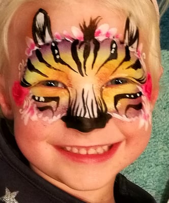 Zebramaske in Regenbogenfarben geschminkt mit Blüten