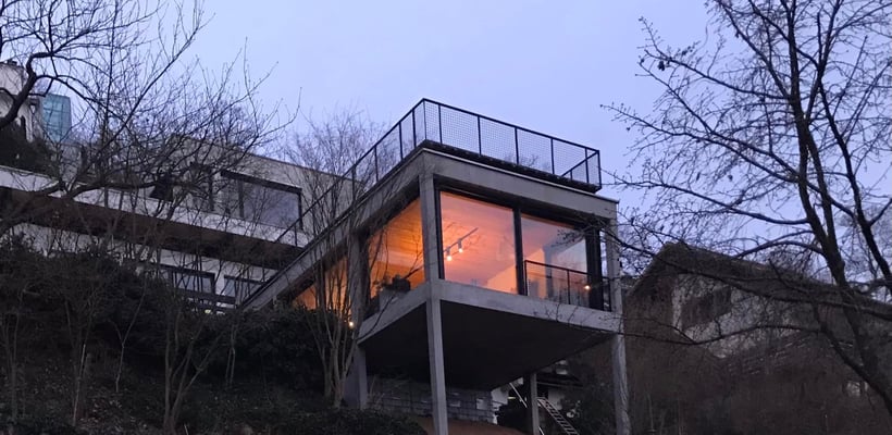 Anbau in schwarzem Beton und Holz am Steilhang Weisenheim