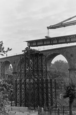 Bau der Behelfsbrücke, die vorgefertigten Stahlelemente werden mit Hilfe eines Schwerlastkrans eingehoben, 1984.