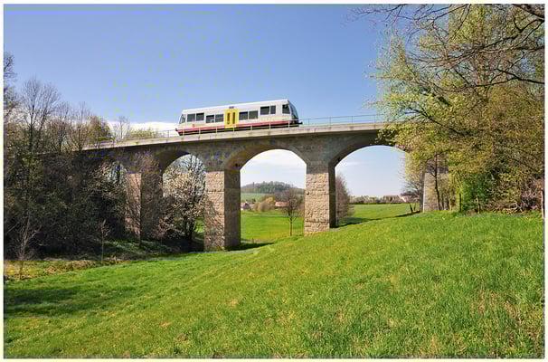 Auf der Rückfahrt nach Neustadt habe ich den kleinen Triebwagen auf dem fotogenen Viadukt bei Langenwolmsdorf abgelichtet. Durch den mittleren Brückenbogen geht der Blick bis zur Burg Stolpen. 27.04.2012