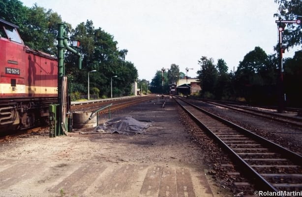 Blick vom Inselbahnsteig in Richtung Ausfahrt Neustadt mit 112 561-6, dem Wasserkran, den Ausfahrsignalen C, D und E, dem Stellwerk 1 (Stw1) und dem Anschluß zum Kohlehandel rechts neben dem Stellwerk. Mai 1990, Foto: Archiv Roland Martini