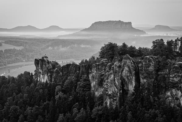 Blick von der Wehlnadel hinüber zur Bastei. Dahinter dominant der Lilienstein, rechts davon der Pfaffenstein. Die eher eintönige Stimmung bewegte mich zur Umwandlung in Schwarz-Weiß.