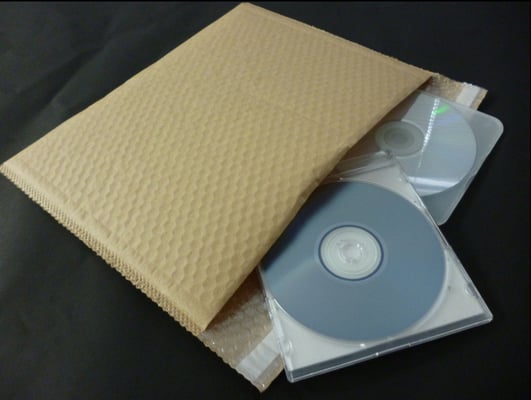 クラフトラミエアセル/封かんテープ付き製袋品に、DVDを梱包して発送する様子。