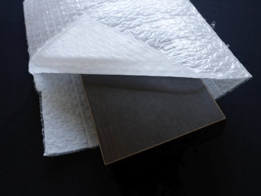 化粧板を不織布をラミネートしたエアセル製袋品（不織布ラミ製品）で梱包した様子。