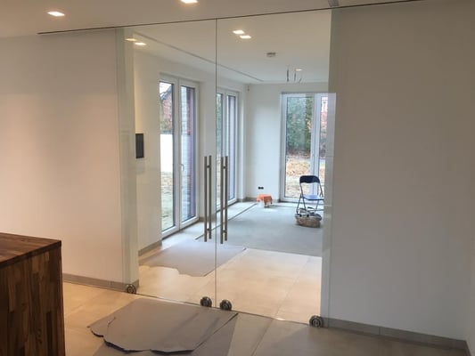 Schiebeanlage mit Edelstahllaufwagen auf dem Boden. Laufprofil im Boden eingelassen.