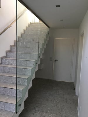 Seitlich an Treppe montierte Brüstung bestehend aus 2 Scheiben mit 4 Punkthaltern und dezenten Profil an der Decke