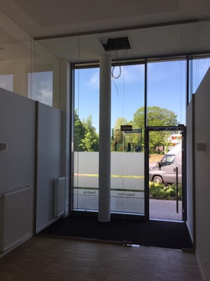 Deckenhoher Raumteiler als Windfang im Eingangsbereich