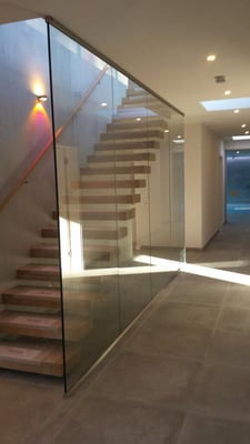 Brüstung seitlich einer Treppe mit einem dezenten Profil an der Decke und auf dem Boden. Verbaut wurde 17mm dickes Vebundsicherheitsglas.