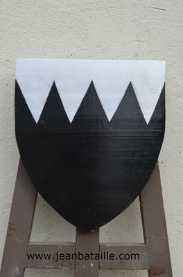 Ecu de sable à l'émanche d'argent mouvante en chef