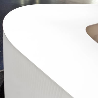 Lenktos formos registratūra iš balto akrilinio akmens verslo centre su grioveliais frezuotu šonu / gamintojas - Gforma