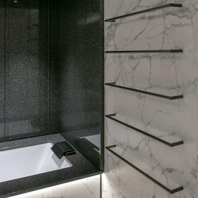 Porcelain bathtub fitted in black Corian surrounded with black solid surface walls