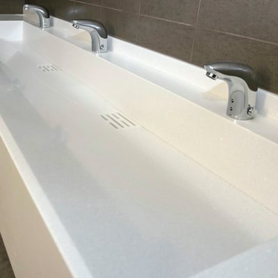 Triple acrylic stone washbasin at a business centre wc with moulded water outlet grille / fabricator: Gforma