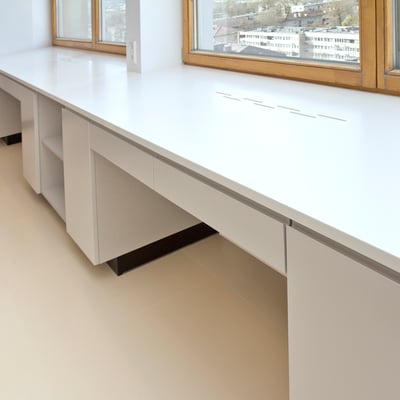 Broad windowsill performing as a writing desk fabricated from white Corian / fabricator - Gforma