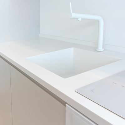 White acrylic solid surface sink integrated into the countertop without visible joints / fabricator: Gforma