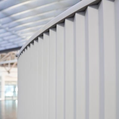 Lenktos formos registratūra iš balto akrilinio akmens verslo centre su grioveliais frezuotu šonu / gamintojas - Gforma